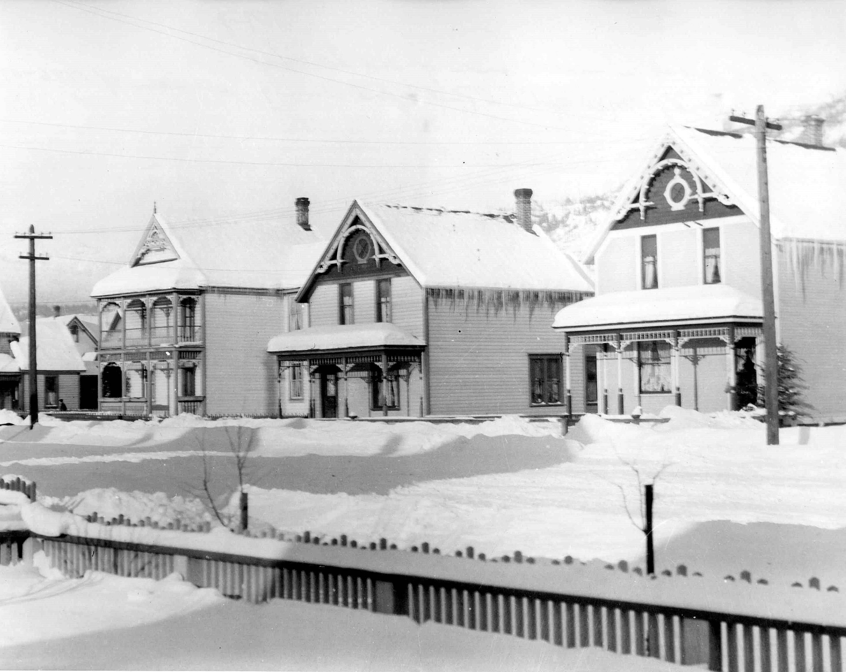 Black and White Photo of Three Homes Covered in Snow